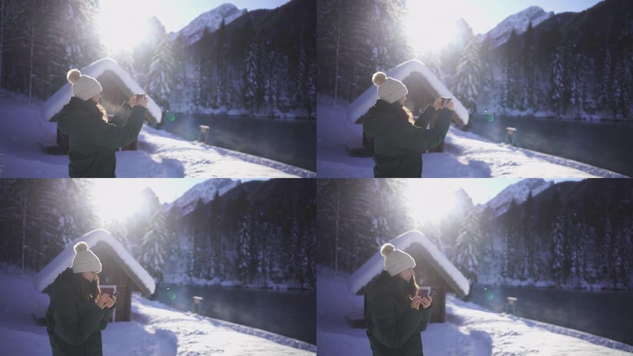年轻女子在白雪皑皑的湖边享受热饮