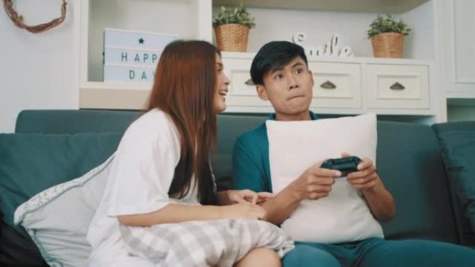 年轻夫妇在家里玩电子游戏很开心。