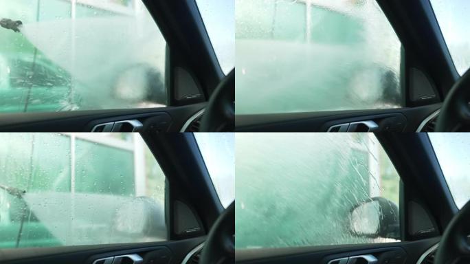 在洗车服务中，从侧窗内用水冲洗射击。高压清洗机在户外清洁汽车玻璃上喷水。
