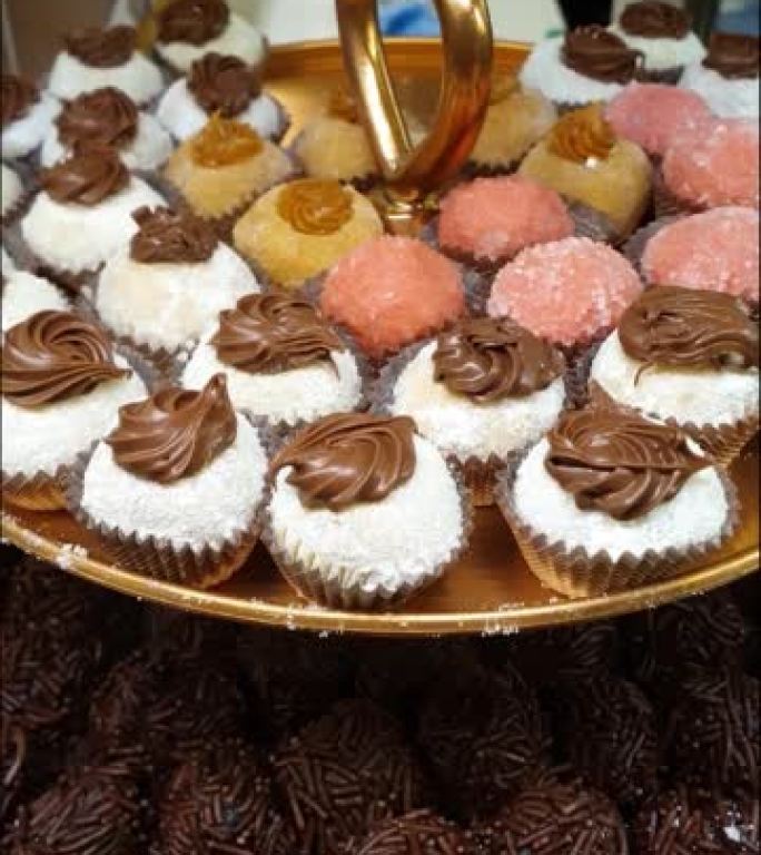 带有巴西巧克力软糖球的小塔，上面涂有榛子奶油的奶粉。连同其他传统的巴西sweets_vertical