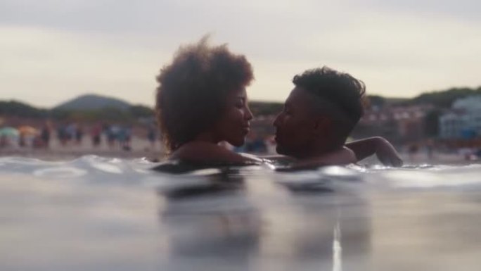 非洲民族浪漫的异性恋夫妇一起在海里游泳。互相拥抱