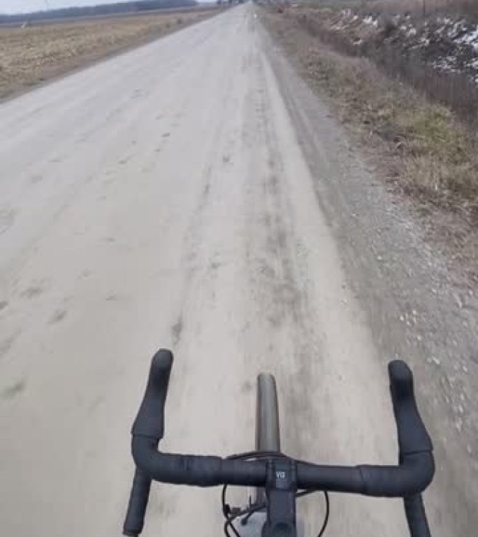 在碎石路上骑自行车时，可以看到平坦的农田