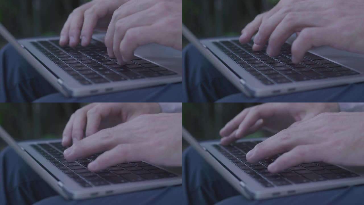 一名男子使用笔记本电脑的细节照片