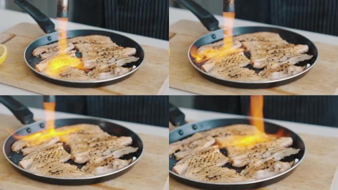 厨师在商用厨房里燃烧鲑鱼片。