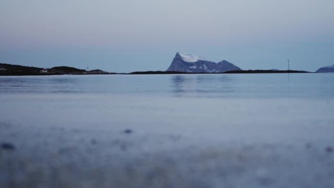 冬天特罗姆瑟海边的风景。积雪覆盖的山脉和杂草