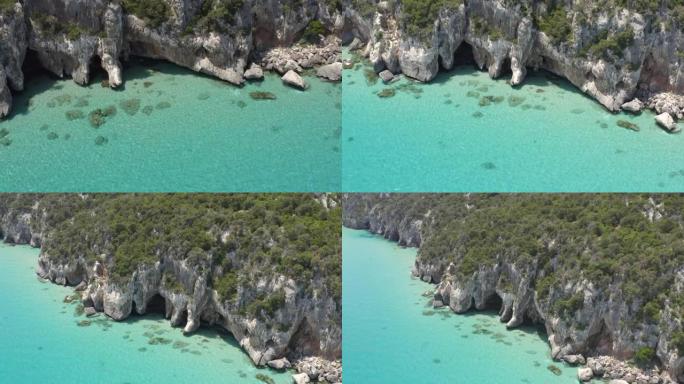 空中无人机拍摄了一个带有洞穴的小岛上的岩石悬崖边