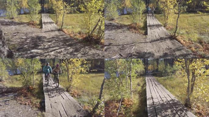 山地车夫妇沿着森林中的木路骑行