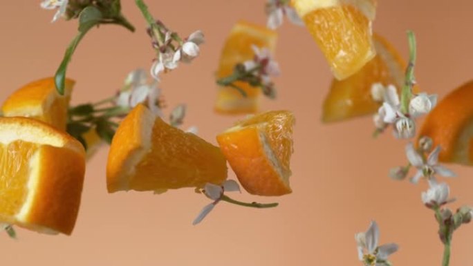 慢动作飞舞的橘子和花朵。用幻影弹性4k相机拍摄。