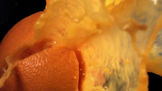 黑色背景4K慢动作的新鲜橙色水果喷射果汁