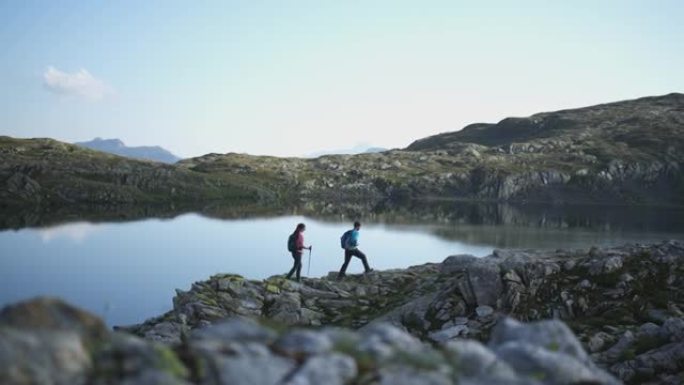 一对夫妇沿着山湖散步的镜头