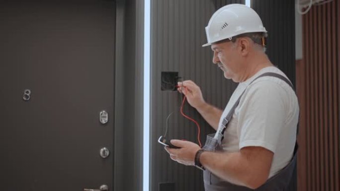 从后面的视图电气在安装和维修后用现代住宅系统检查灯具墙壁控制单元的操作