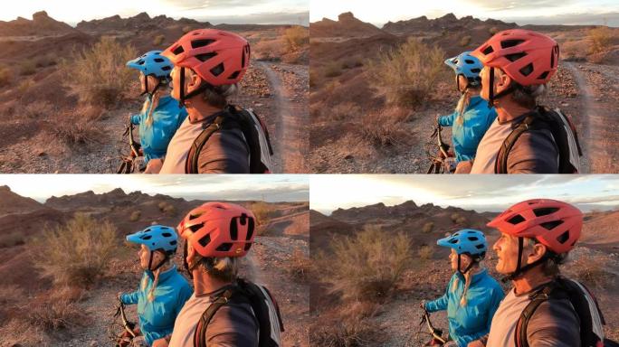 山地自行车夫妇在沙漠上享受最后的阳光