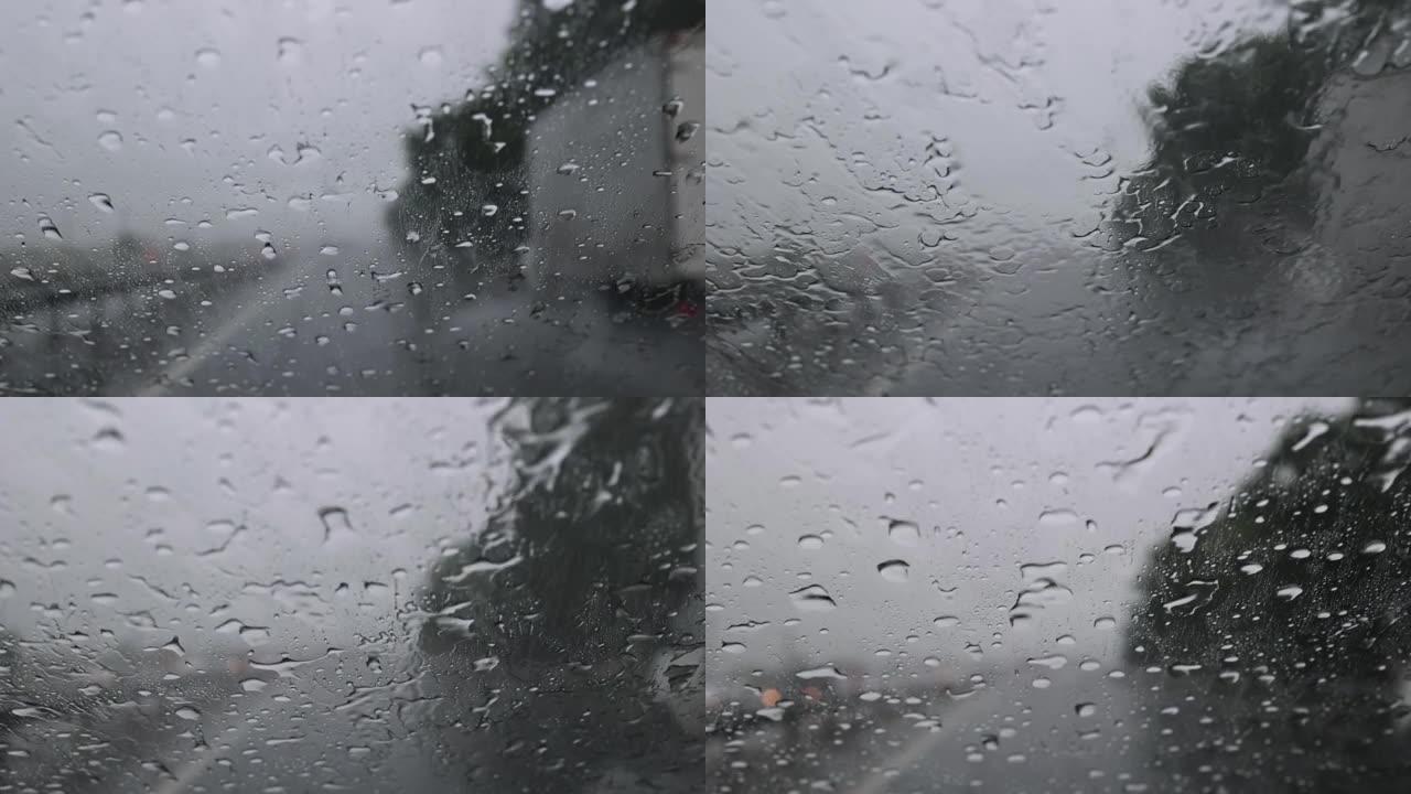 雨水落在用防水蜡处理过的汽车的挡风玻璃上。倾盆大雨时，在高速公路上驾驶汽车，车内行驶，迎面而来的汽车