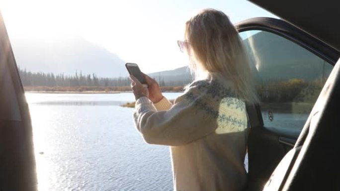 女人打开车门欣赏美丽的山景