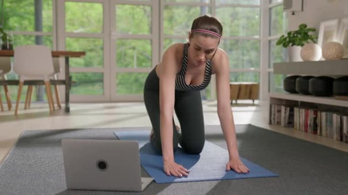 女运动员为锻炼准备瑜伽垫。家庭锻炼