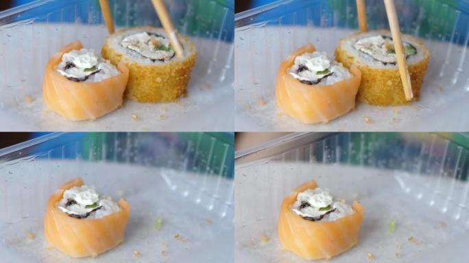 close-up appetizing sushi is taken with chopsticks