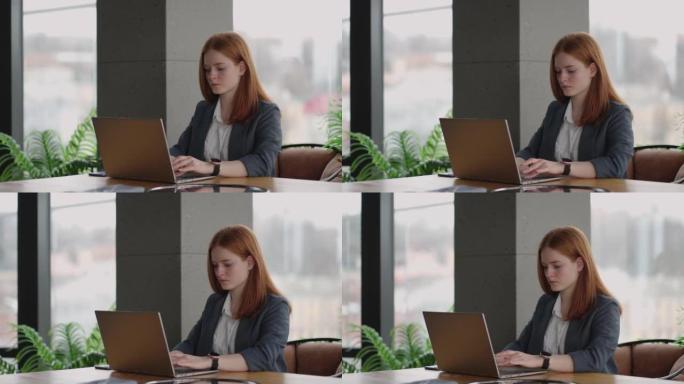 成功的女老板在现代办公室用笔记本电脑工作，漂亮的女士在工作聊天中输入信息