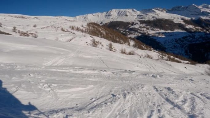 在阳光明媚的日子里，滑雪者从白雪皑皑的山腰下降的第一人称视角