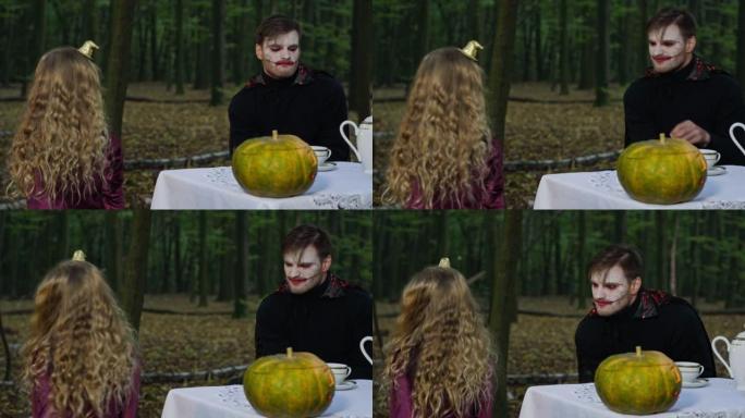 万圣节吸血鬼化妆的男人吓唬女孩做鬼脸，当孩子试图吓唬神秘实体时。10月31日在户外森林里积极庆祝节日