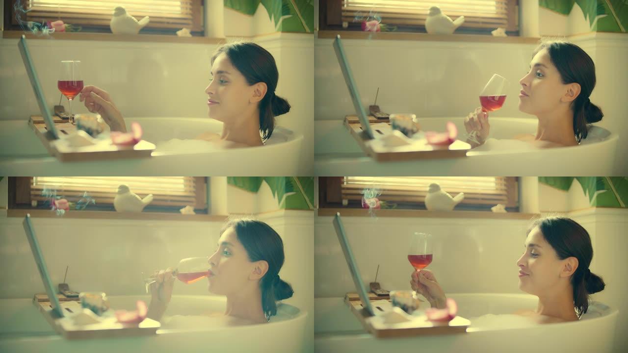 在浴室看电影。一个女人在浴缸里用笔记本电脑，喝着饮料吃着零食