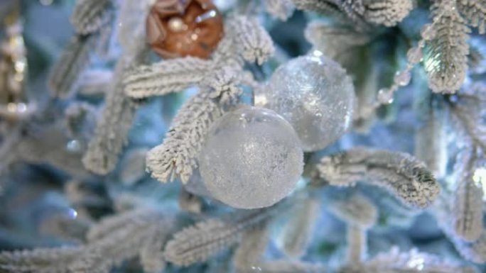 传统人造圣诞树，背景为透明球装饰和发光蓝光