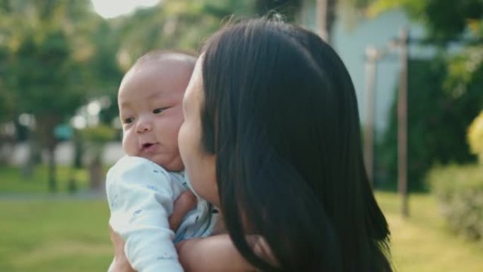 天真的男婴在阳光明媚的日子和他的母亲一起放松。