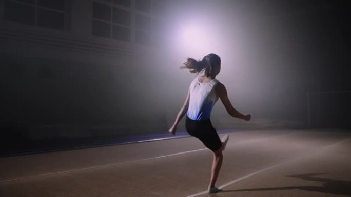 年轻女运动员在春季地板上表演，训练艺术家体操的自由体操，慢动作