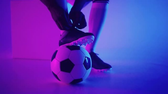 演播室足球运动员脚下慢动作的足球特写镜头。工作室里有球的职业足球运动员