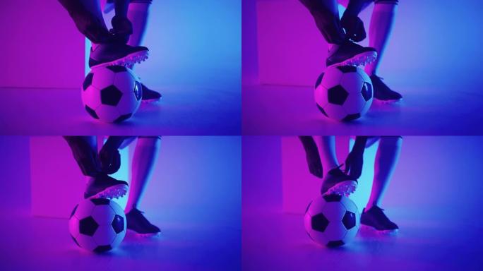 演播室足球运动员脚下慢动作的足球特写镜头。工作室里有球的职业足球运动员