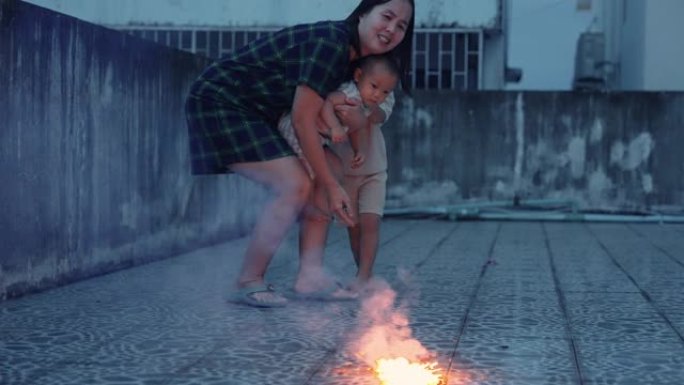 有母亲和两个儿子的亚洲家庭喜欢一起在屋顶上玩烟火和烟火