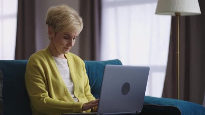 退休妇女在家远程工作，通过笔记本电脑打字和发送信息，在互联网上从事自由职业