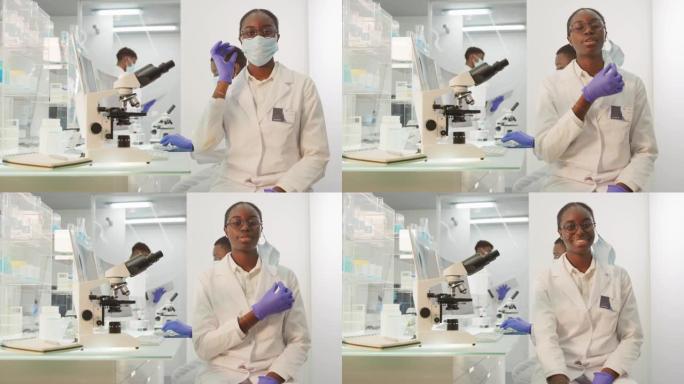 非洲女科学家对她的工作感到满意。看着相机，摘下面具。未来主义的现代实验室