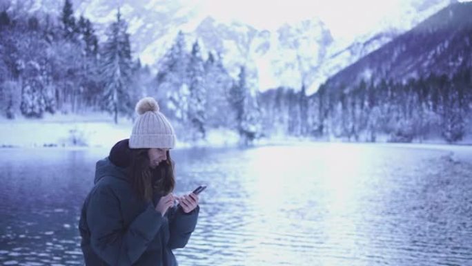 年轻女子在白雪皑皑的湖边自拍