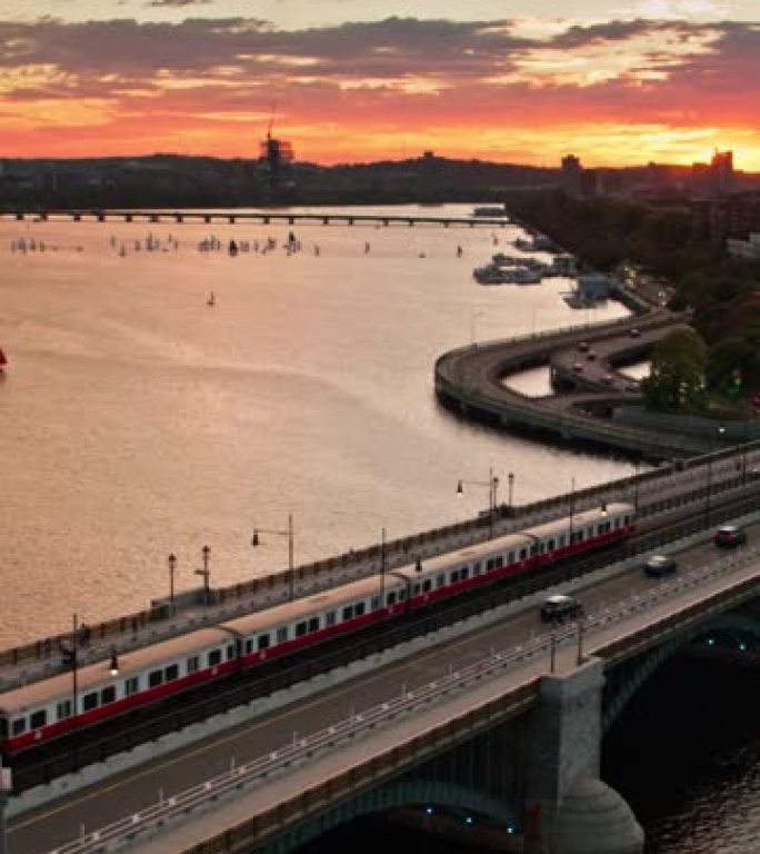太阳与地平线相遇时，火车穿越朗费罗桥的垂直无人机拍摄