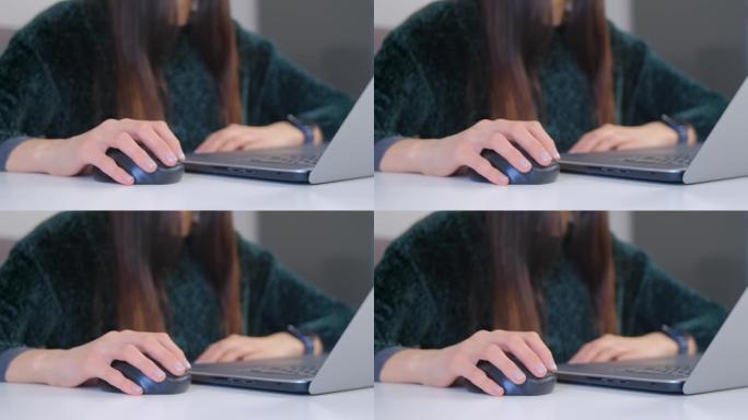 自由职业者女性工作电脑，用无线鼠标机械手点击