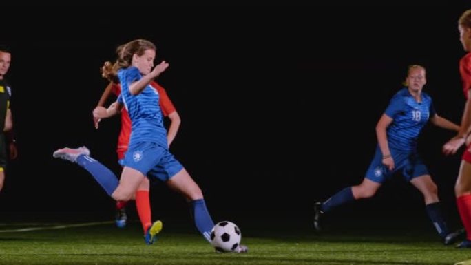 穿着蓝色服装的SLO MO TS女足球运动员在晚上的比赛中踢球