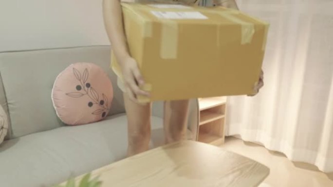 亚洲妇女的场景慢动作将她从网上购物中购买的包装盒带回家