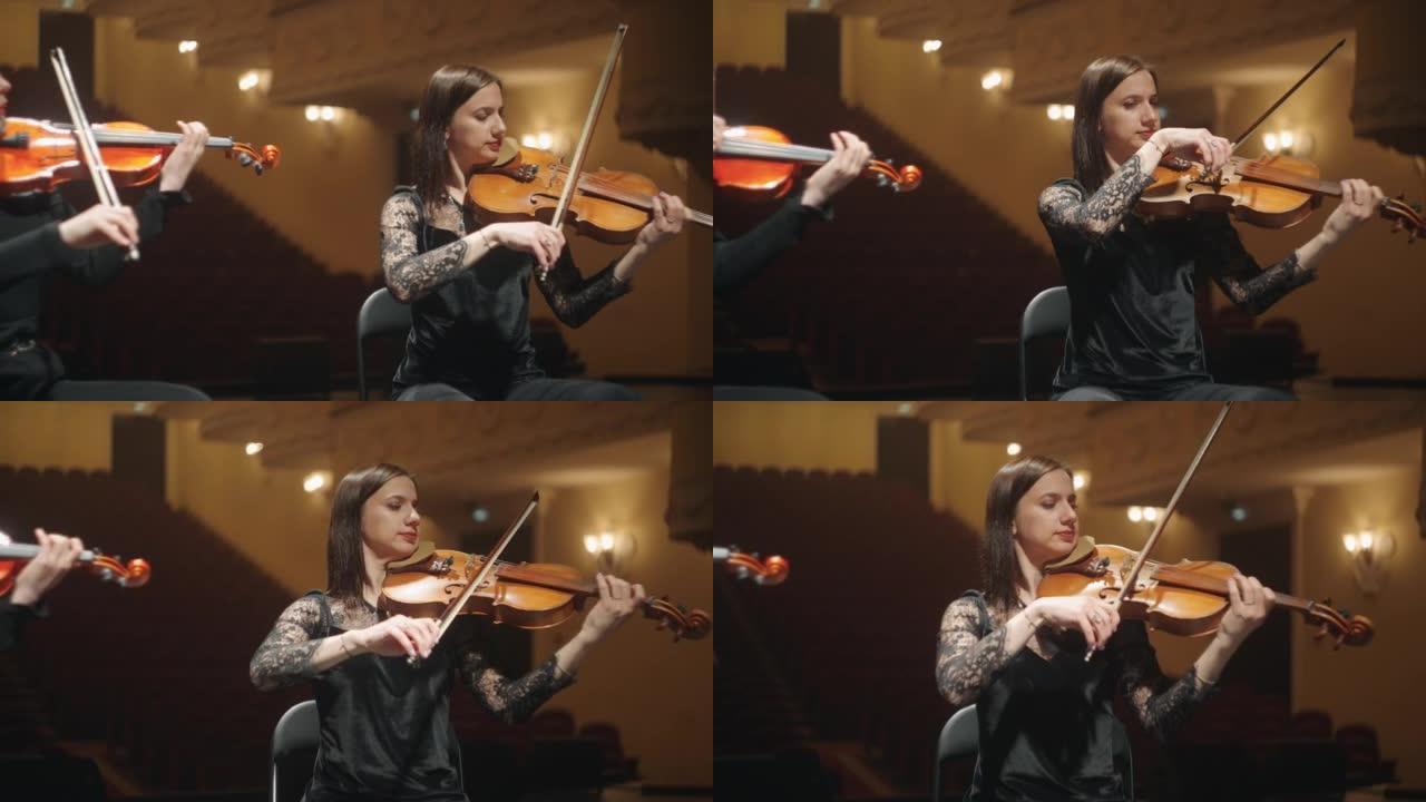 女小提琴家在音乐厅现场演奏音乐，爱乐乐团的专业音乐家