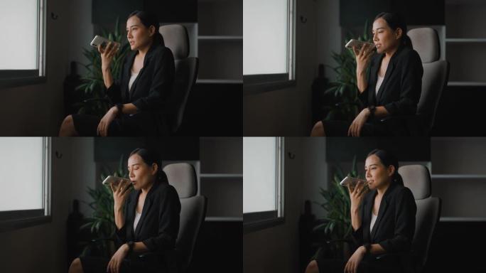 亚洲白领女性在办公室里用智能手机聊天。