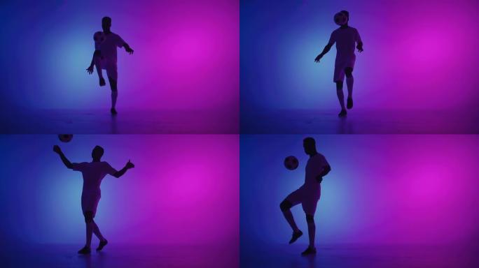 黑人一名球员在黑暗的工作室里玩足球，地板上有霓虹灯，慢动作中有红色和蓝色的灯光效果。非洲职业足球运动
