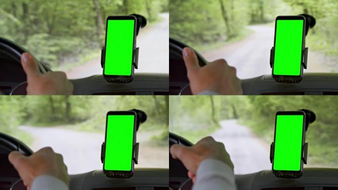 LD男子借助智能手机上的导航在森林道路上驾驶汽车