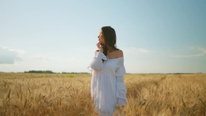 肖像漂亮的褐发女人在白色的裙子在金色的黑麦田野，美丽的女士松散的头发