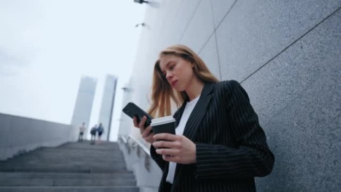 繁忙的女商人画像在市中心用手机在网上聊天发短信