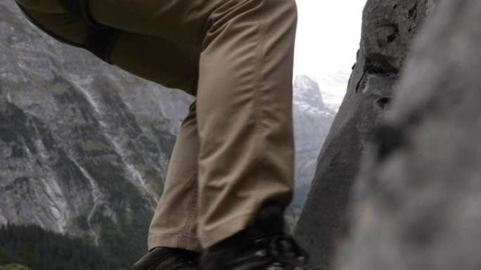 男性登山者登上陡峭的岩石面