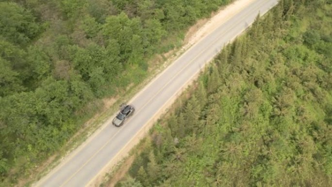 在森林道路上方飞行的鸟瞰图，单车行驶