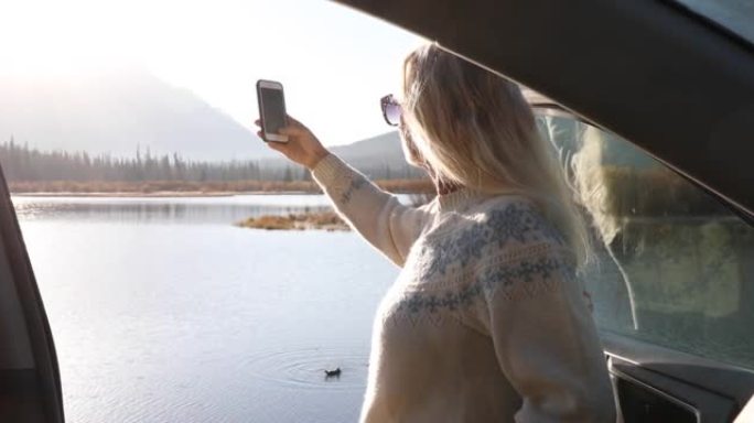 女人打开车门欣赏美丽的山景