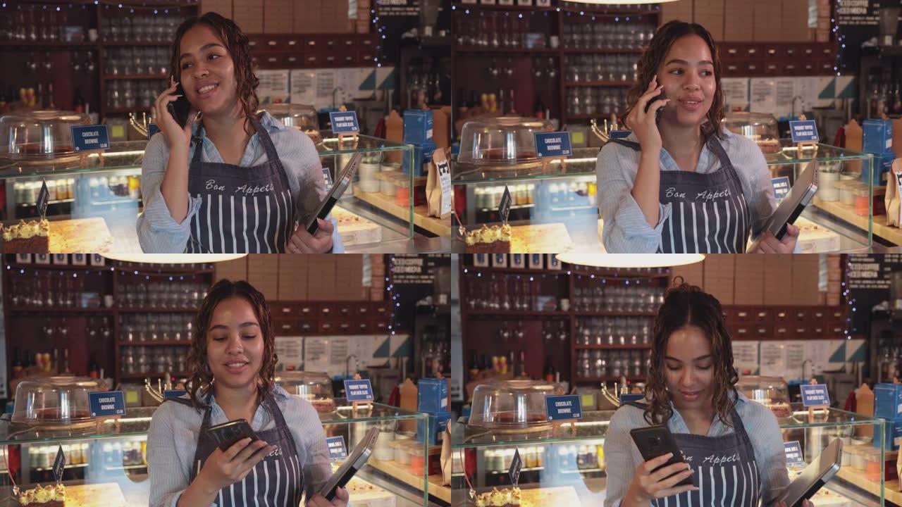 年轻女子在咖啡馆工作时使用手机