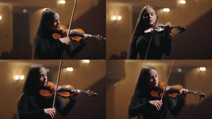 青年学生小提琴手在音乐厅演奏小提琴，交响乐团的女提琴手肖像