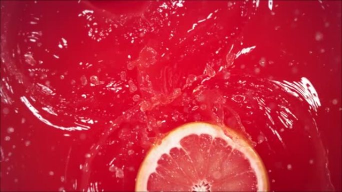 葡萄柚飞溅地落在果汁上，分成两半。