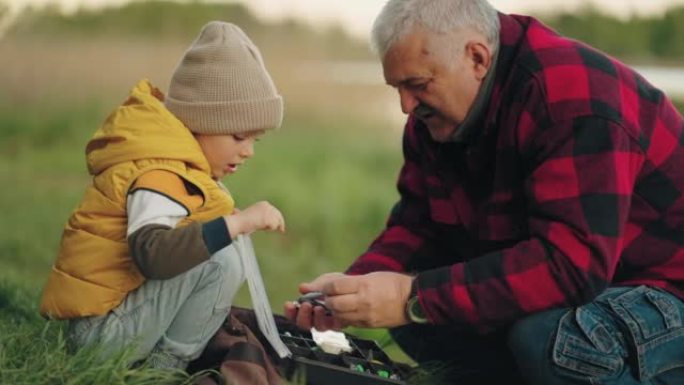 老渔夫正在向孙子展示渔具，祖父正在教小男孩